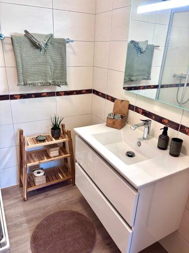 a bathroom with a sink and a mirror at Lake View in Le Sentier