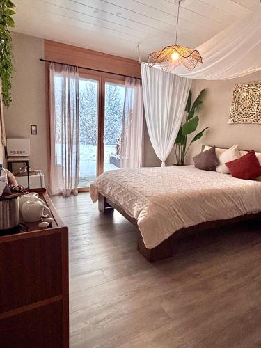 a bedroom with a large bed and a large window at Lake View in Le Sentier