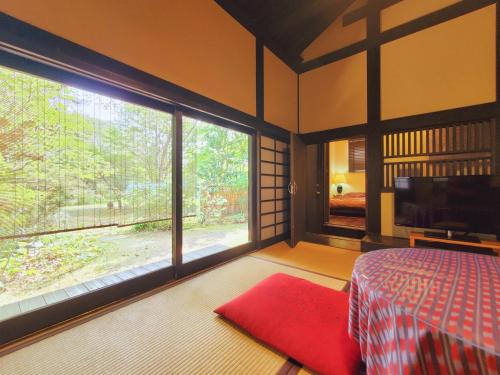 a bedroom with a bed and a large window at shoya yamaguchi in Koibuchi