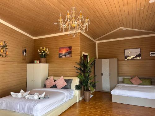 a bedroom with two beds and a chandelier at Cocoloco Pool Villa Ao Nang in Ao Nang 