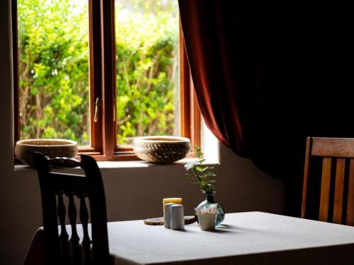 a table with a white table cloth and a window at Namibgrens Guest Farm in Namibgrens