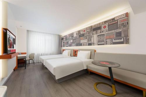 a hotel room with two beds and a table at Ibis Dalian Development Zone Wanda Plaza in Jinzhou