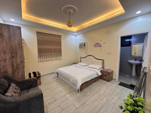a bedroom with a bed and a couch and a sink at شاليهات سكون الغروب in Taif