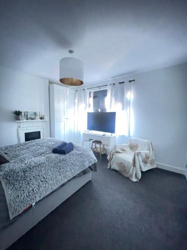 a bedroom with a bed and a desk in it at Artsy Minimalist Suite in Southend-on-Sea
