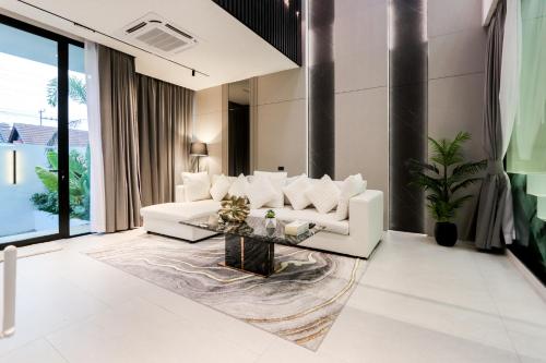 a living room with a white couch and a table at Indiluxe pool villa in Pattaya South