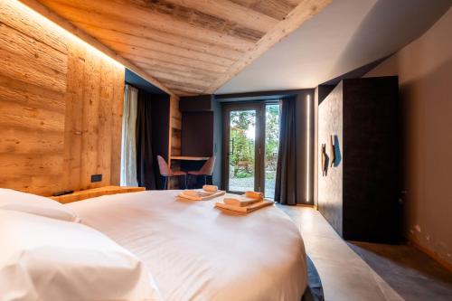 a bedroom with a large white bed with a window at Le Suites de San Campel RTA in Ponte di Legno