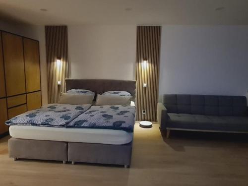 a bedroom with a bed and a couch at Ferienwohnung Nideggen, Eifel, Nähe Ruhrsee, Nationalpark in Nideggen