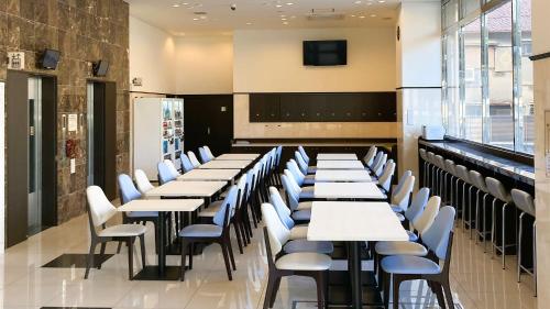 a row of tables and chairs in a restaurant at Toyoko Inn Osaka Kadoma-shi Ekimae in Osaka