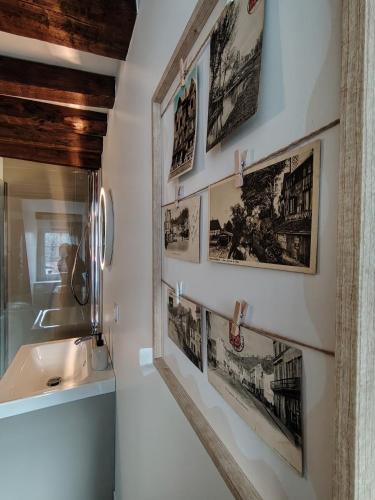 a bathroom with a sink and pictures on the wall at Appartement rénové centre Pont-Audemer-calme, Wi-Fi, proche Honfleur in Pont-Audemer