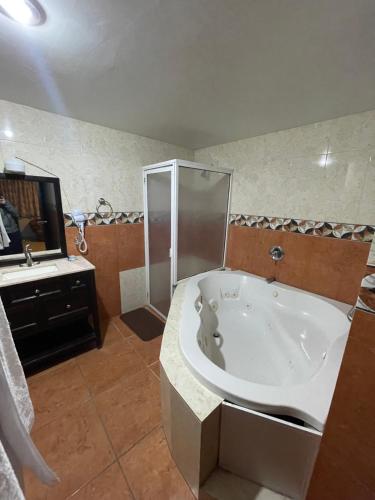 a bathroom with a large tub and a sink at Camino de la Plata Hotel in Fresnillo de González Echeverría