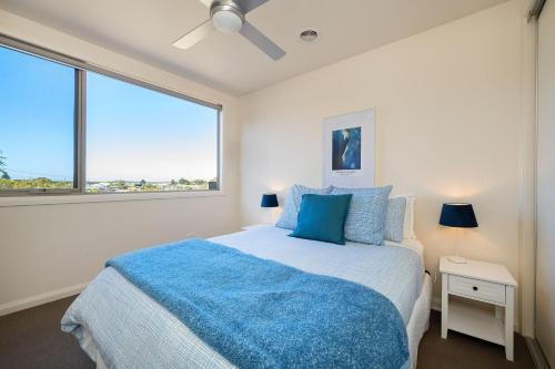 a bedroom with a bed and a large window at Blue Horizons at Ocean Grove in Ocean Grove