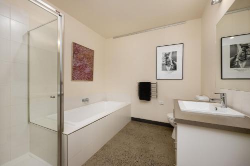 a bathroom with a tub and a sink and a shower at Blue Horizons at Ocean Grove in Ocean Grove