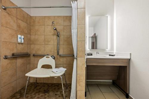 a bathroom with a sink and a shower with a chair at Comfort Suites Cullman I-65 Exit 310 in Cullman