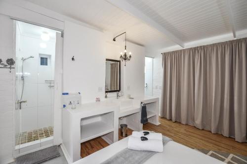 a white bathroom with a sink and a shower at Hoekkraaltjie in Yzerfontein