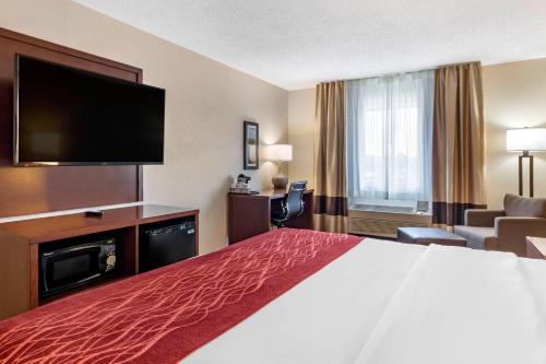 a hotel room with a bed and a flat screen tv at Comfort Inn Great Falls South in Great Falls