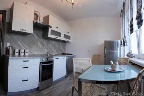 a kitchen with white cabinets and a table and a dining room at Gościniec w Malborku in Malbork