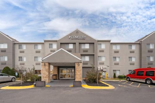 a large building with a van parked in a parking lot at Country Inn & Suites by Radisson, Fairview Heights, IL in Fairview Heights