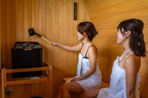 two women in a room looking at a wand at Sunset SPA Resort AJI by SETO CLAS in Takamatsu