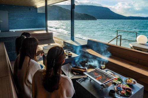 a group of people sitting on a boat cooking food at Sunset SPA Resort AJI by SETO CLAS in Takamatsu