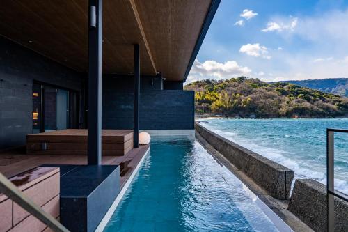 a house on the water with a infinity pool at Sunset SPA Resort AJI by SETO CLAS in Takamatsu