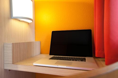 a laptop computer sitting on a desk in a room at Première Classe Epinay Sur Orge Savigny Sur Orge in Épinay-sur-Orge