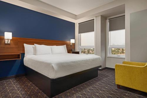 a hotel room with a bed and a chair at Park Inn by Radisson, Kelowna in Kelowna