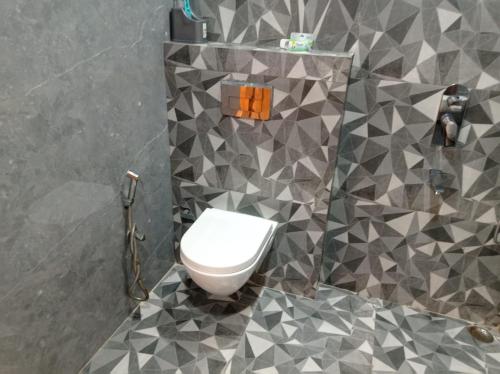 a bathroom with a white toilet in a room at sariska farmhouse villa in Alwar