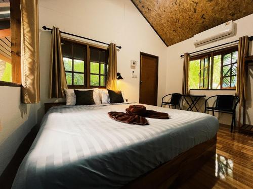 a bedroom with a bed with a robe on it at Decoco Canal-side Homestay in Ban Khlong Duang