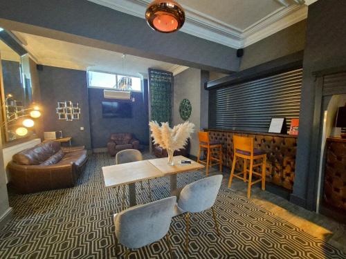 a living room with a couch and a table and chairs at OYO Ivy Hotel in Skegness