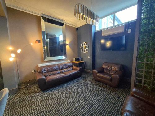 a living room with a couch and two chairs at OYO Ivy Hotel in Skegness