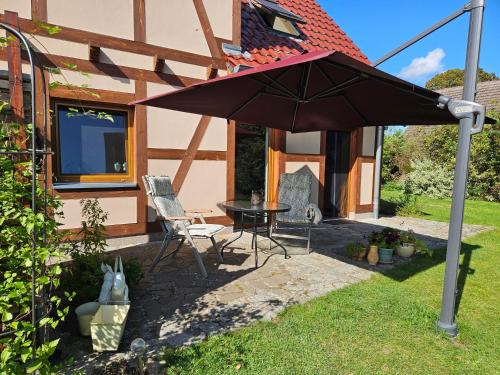 a patio with a table and an umbrella in the yard at Ferienwohnung Peetsch am See in Mirow