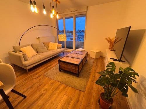 a living room with a couch and a table at L'appartement du Château in Pfastatt