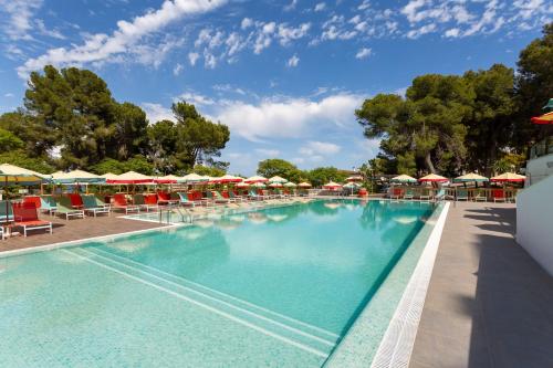 a large swimming pool with chairs and umbrellas at Alua Calvia in Magaluf