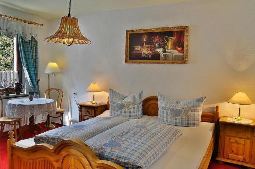 ein Schlafzimmer mit einem Bett mit blauen Kissen in der Unterkunft Pension Fuhrmann's Elb- Café in Bad Schandau