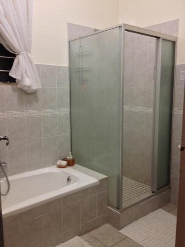 a bathroom with a tub and a glass shower at The Nook B&B in Kimberley