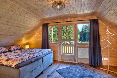 a bedroom with a bed in a room with a window at Manus Hoizhütterl in Sankt Oswald