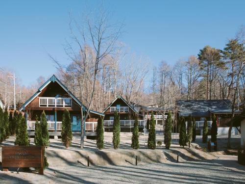 a house with christmas trees in the snow at YATSUGATAKE KOGEN RESORT in Hokuto