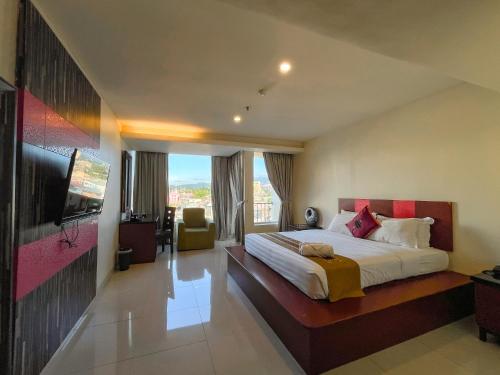 a bedroom with a large bed and a television at Lion Hotel & Plaza Manado in Manado