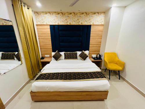 a bedroom with a bed and a yellow chair at Hotel Diamond Villa and Banquet in Amritsar
