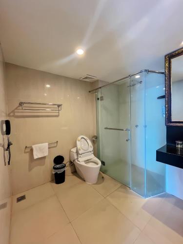 a bathroom with a toilet and a glass shower at Lion Hotel & Plaza Manado in Manado