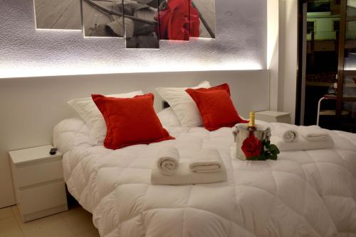 a large white bed with red pillows on it at Hostal El Júcar in Alcalá del Júcar