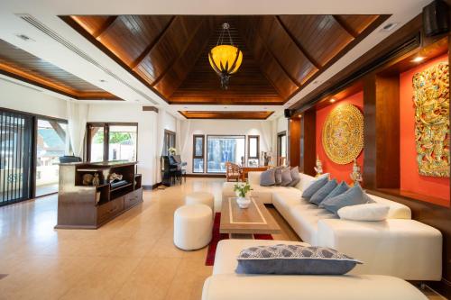a living room with white couches and a table at D Villa Phuket - Luxury 6 Bedroom Private Pool Villa in Cape Panwa in Phuket