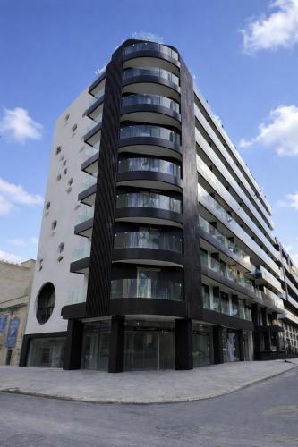 ein hohes Wohnhaus mit schwarzem in der Unterkunft ASTE hotel in St Julian's
