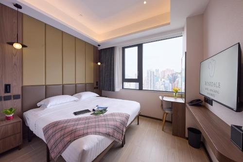 a hotel room with a bed and a flat screen tv at Rosedale Hotel Hong Kong in Hong Kong