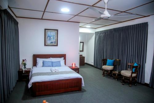 a hotel room with a bed and two chairs at BansriVilla Mount Lavinia in Mount Lavinia