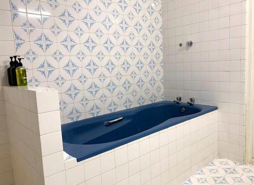 a blue tub in a white tiled bathroom at BansriVilla Mount Lavinia in Mount Lavinia