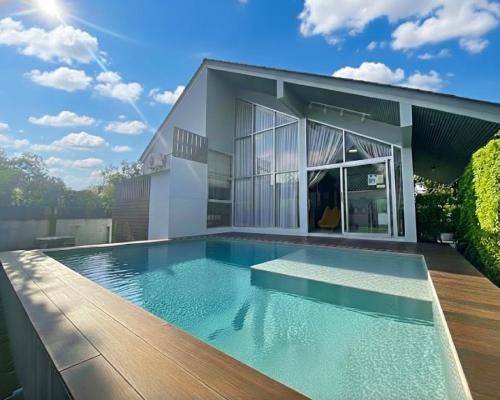 a swimming pool in front of a house at Pool villa 3 BR 10 Persons 5-min to tiger zoo - Njoy Pool villa in Si Racha