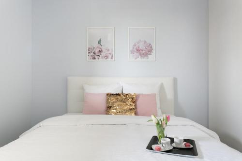 a white bed with a tray with flowers on it at Dream destination in Montévrain