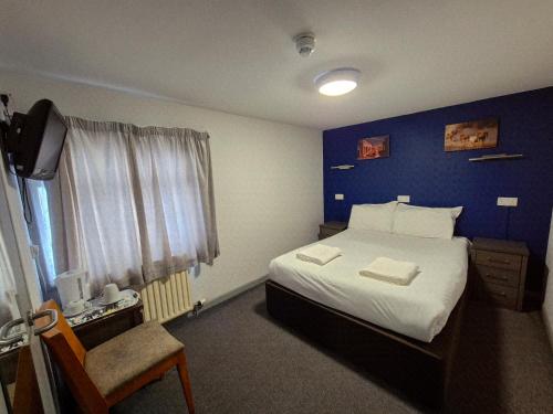 a bedroom with a bed with a blue wall at OYO Ivy Hotel in Skegness