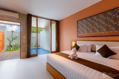 a bedroom with a bed with a teddy bear sitting on it at ME Villa Pererenan in Canggu